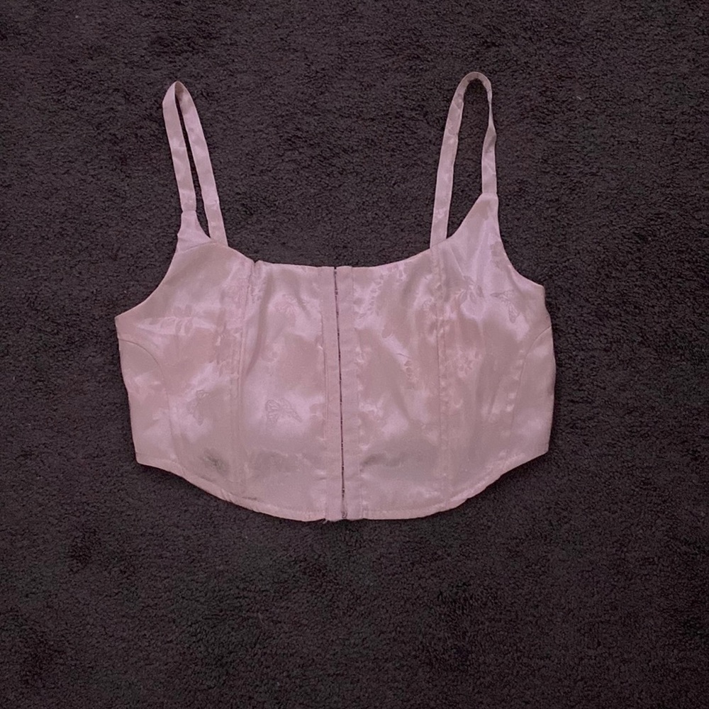 A satin baby pink corset top with flowers and butterflies embroidered
